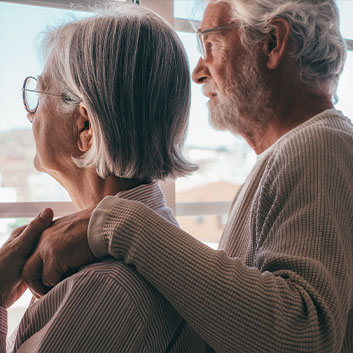 Older couple holding hands and looking out of window together. Read about Gifts of Appreciated Securities Older couple holding hands and looking out of window together. Read about Gifts of Appreciated Securities