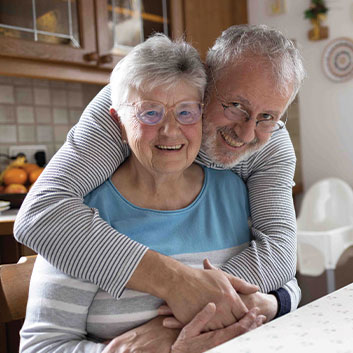 Husband giving his wife a hug and smiling together. Read about Closely Held Business Stock Husband giving his wife a hug and smiling together. Read about Closely Held Business Stock