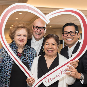 People posing for a photo within a heart cutout. Read about Tangible Personal Property People posing for a photo within a heart cutout. Read about Tangible Personal Property